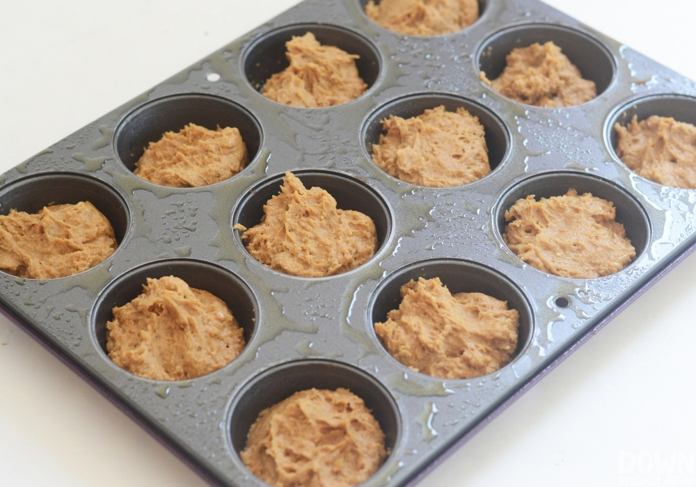 Muffin batter in a muffin pan ready to go in the oven.