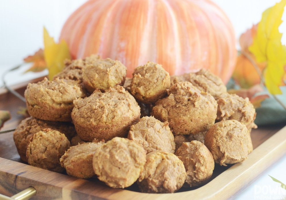 Close up of a pile of freshly baked mini pumpkin muffins.