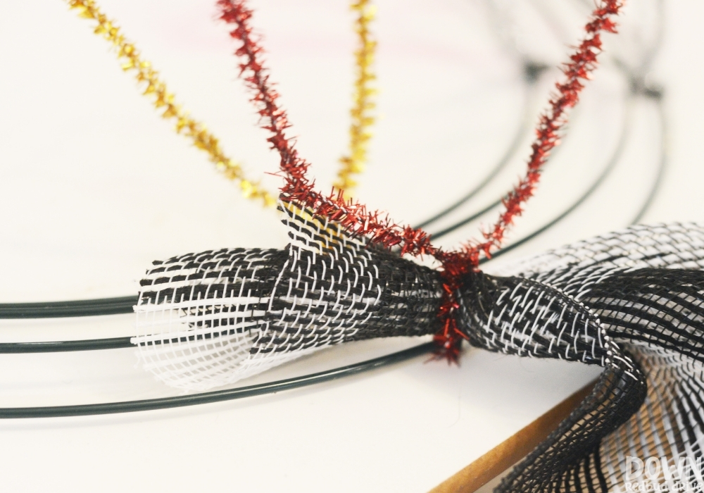 Black and white checkered deco mesh being attached to a wreath form.