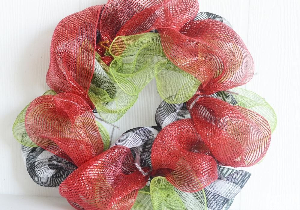 The red, green and buffalo check deco mesh added to a wreath form for the Christmas Mesh Wreath DIY.