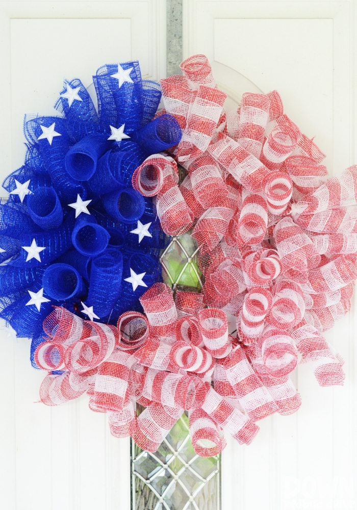 Tall shot of the finished DIY American Flag Mesh Wreath on a white door.