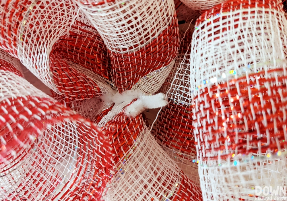 Closeup of the deco mesh attached to a wreath form with chenille stem pipe cleaners.