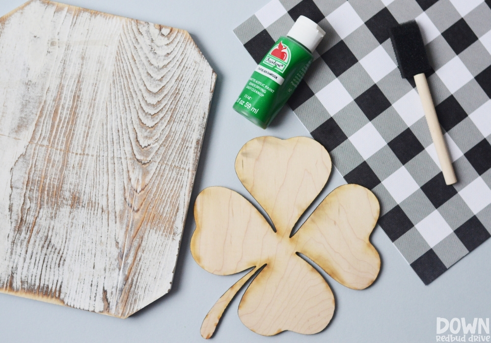 Overhead view of the supplies for the DIY buffalo plaid shamrock sign.