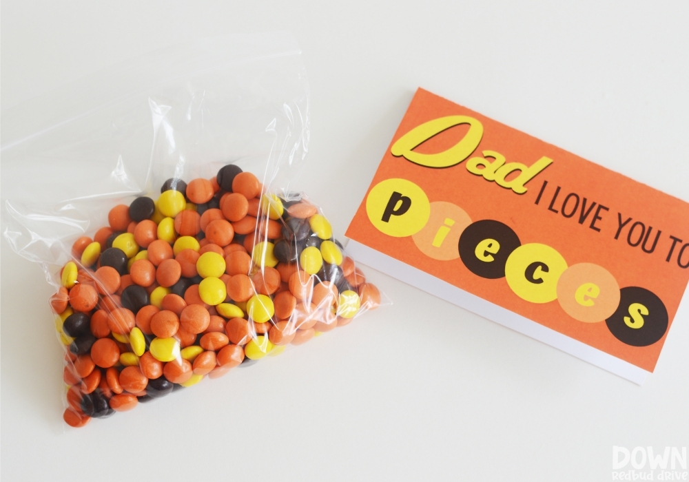 Overhead view of a bag of Reese's Pieces next to a printable tag that says "Dad I Love You To Pieces".