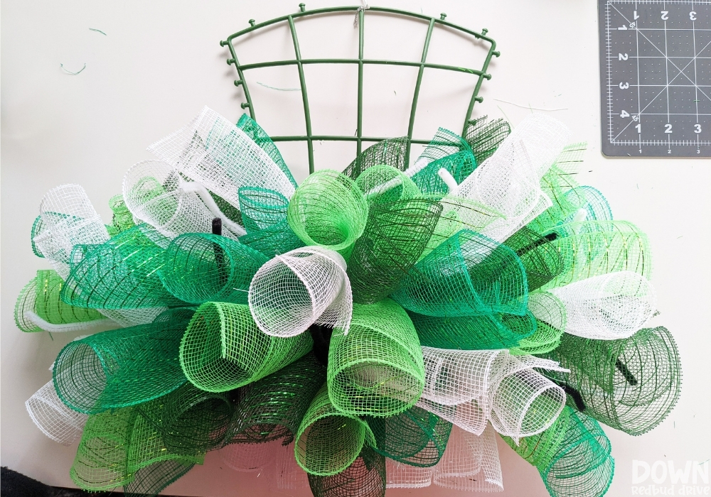 Green and white mesh attached to a hat wreath base.