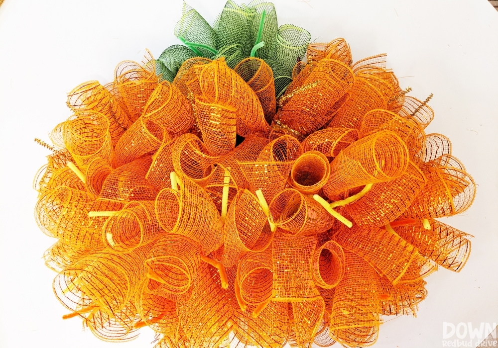 The orange deco mesh done being attached for the DIY Mesh Pumpkin Wreath.