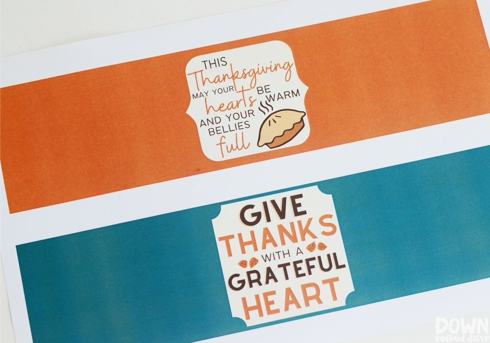 Closeup of printable candle tags that say "This Thanksgiving may your hearts be warm and your bellies full" and "Give thanks with a grateful heart".