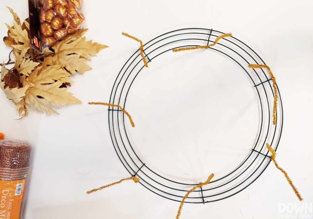 Gold pipe cleaners attached to a wire wreath form.