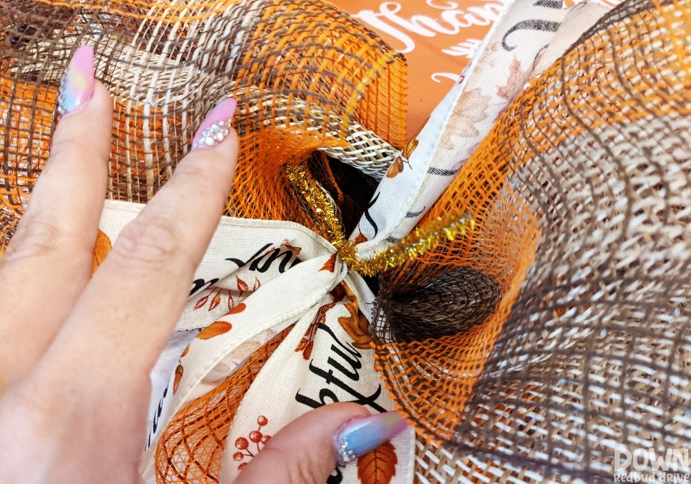 Closeup of the "Thankful" ribbons attached to the wreath form with gold pipe cleaners.