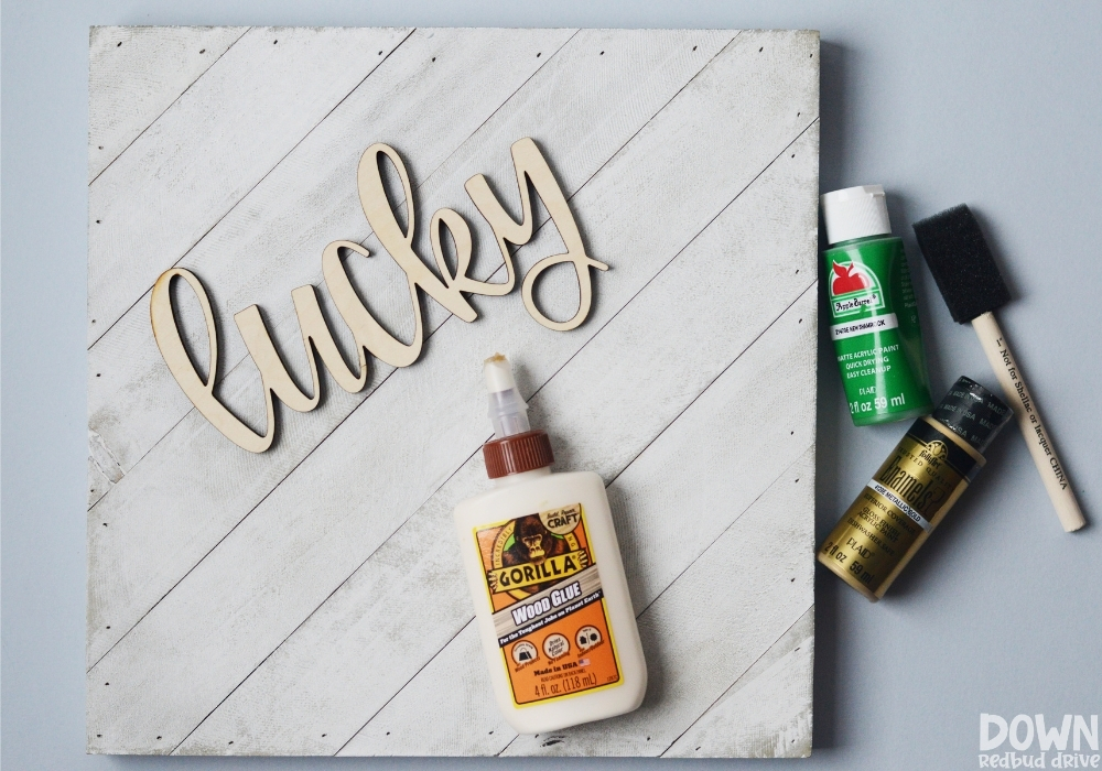 Overhead view of the supplies for the DIY wooden lucky sign.