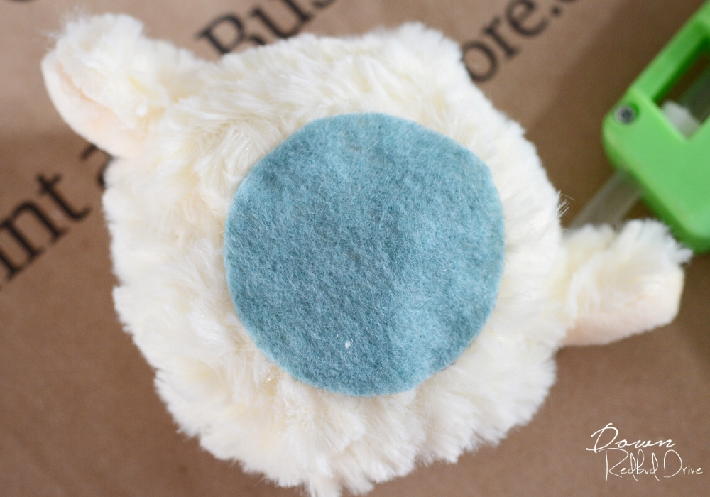 a blue felt circle on the bottom of a stuffed lamb's head