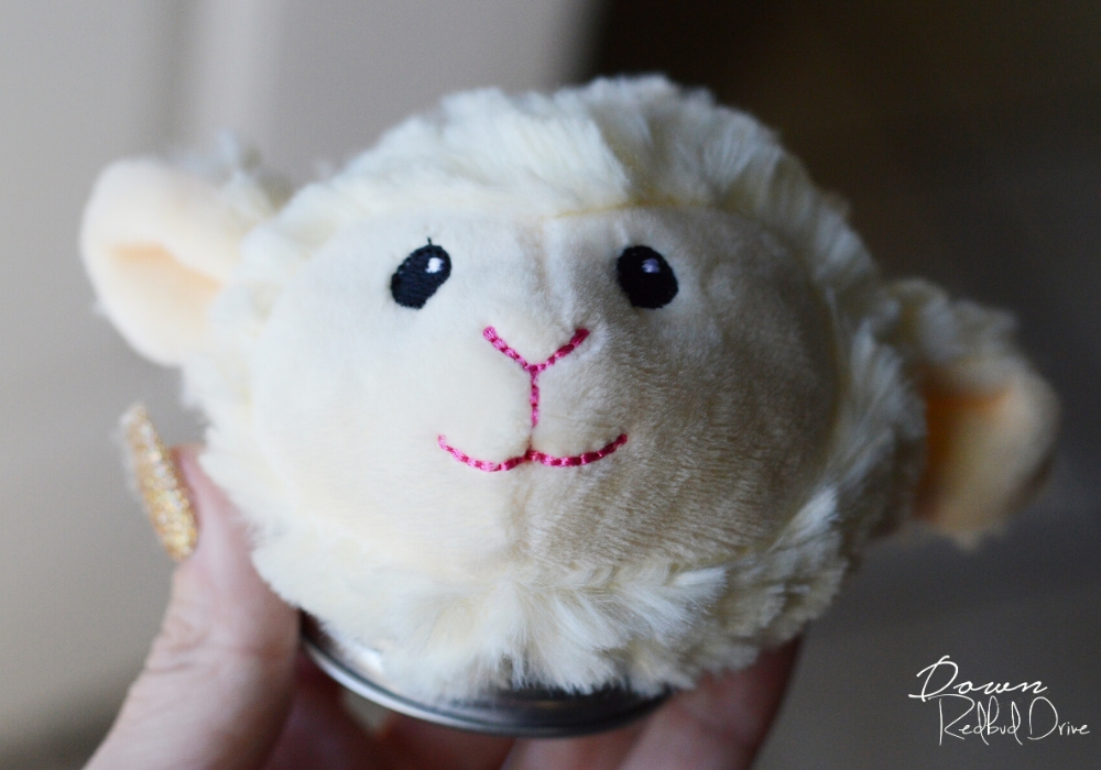 a stuffed lamb's head attached to a jar lid