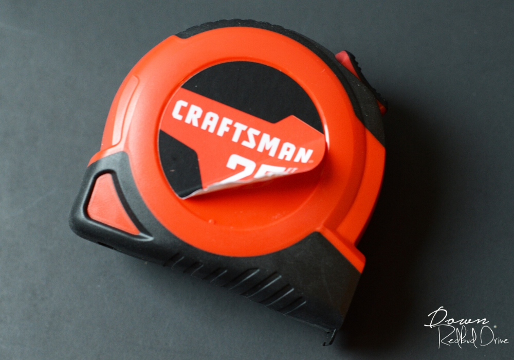 a red and black craftsman tape measure with the label peeling off on a black background