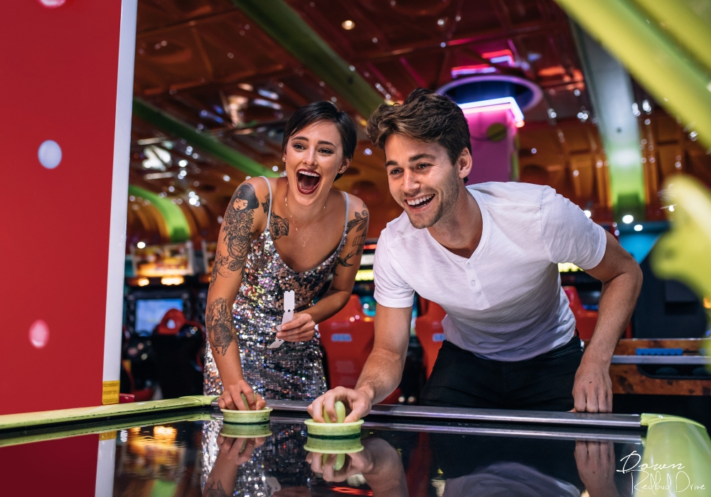 couple playing air hockey at an arcade