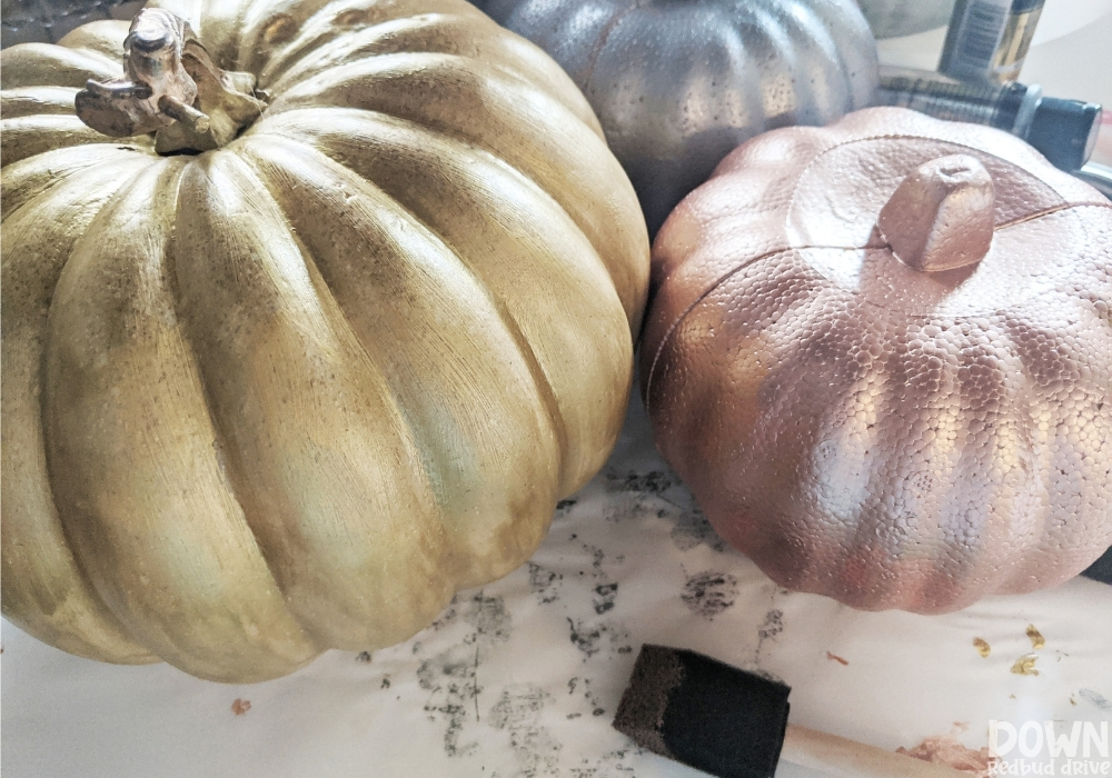 Overhead shot of foam pumpkins painted metallic gold, bronze and silver.