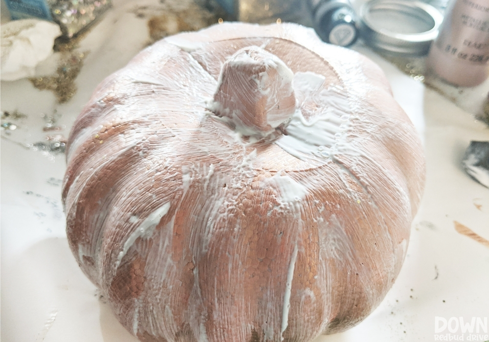 A bronze painted foam pumpkin covered in Hodge Podge to be covered in glitter.