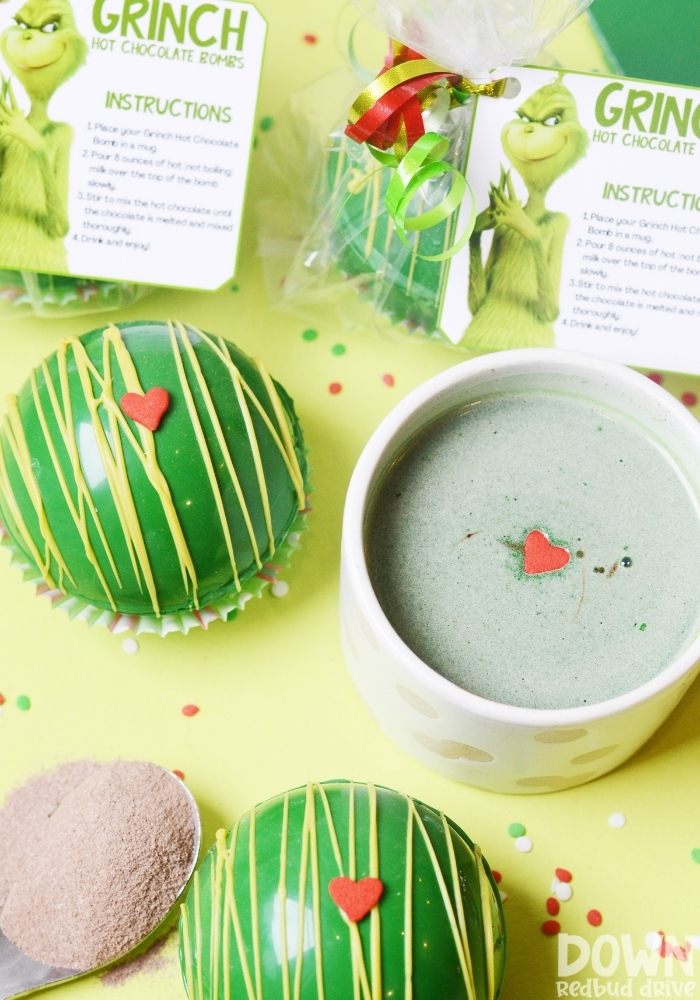 A tall closeup of a cup of hot cocoa made with a Grinch Hot Chocolate Bomb.