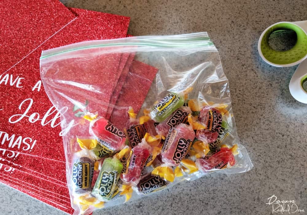 Bag of Jolly Ranchers next to Holly Jolly Christmas printable tags