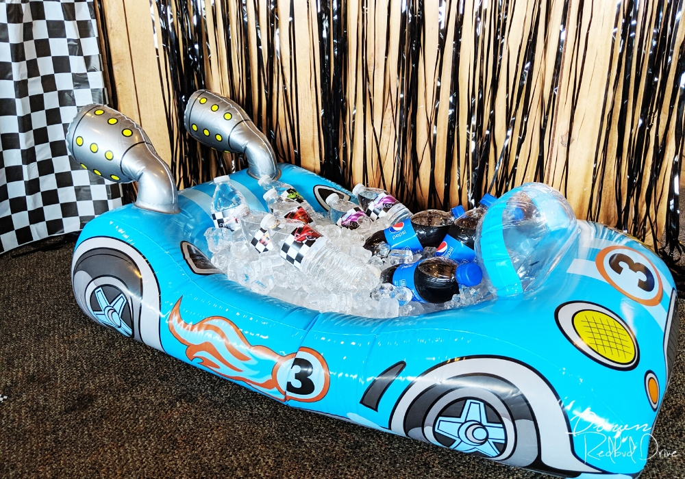 inflatable blue car on the floor with ice and water bottles in it