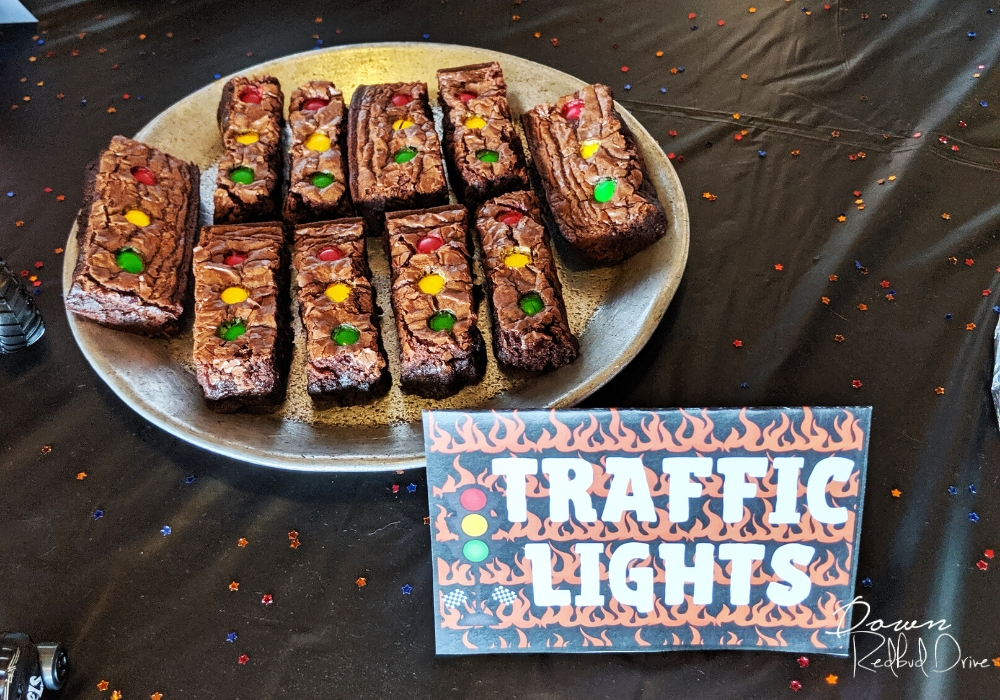 brownies cut in rectangles with red, yellow, and green M&M's on them in a line to look like a traffic light with traffic light food cards