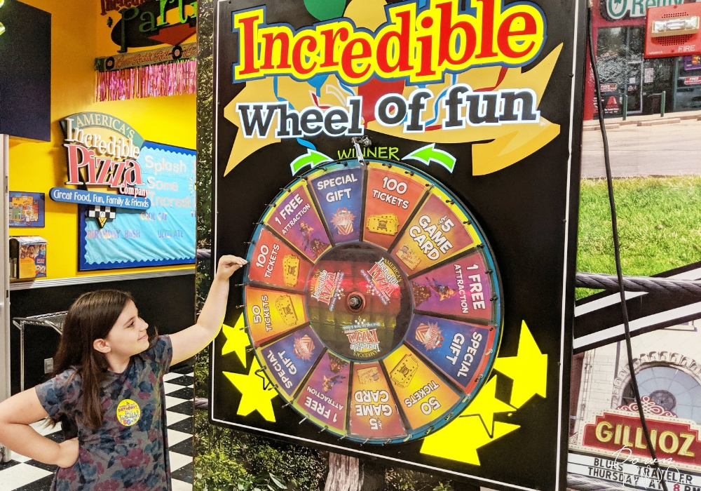 girl spinning the Incredible Wheel of Fun at Incredible Pizza