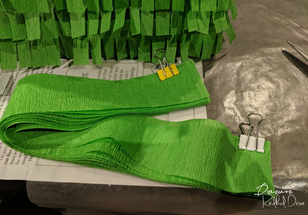 strips of green paper streamers being held together with small binder clips