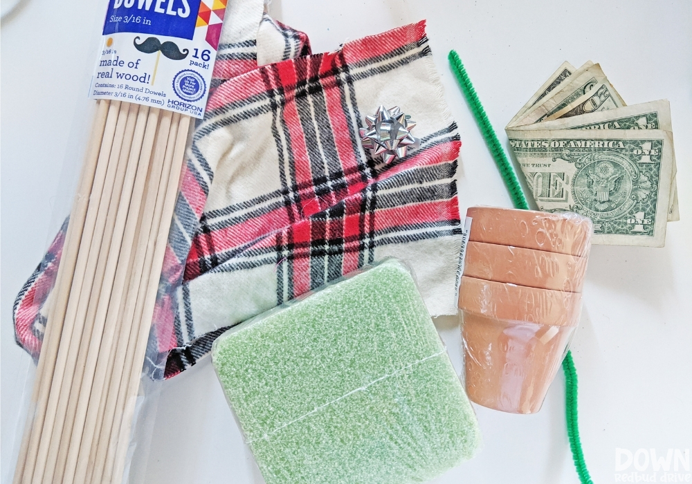 Overhead shot of the supplies for the money Christmas tree gift DIY laid out on a white background.