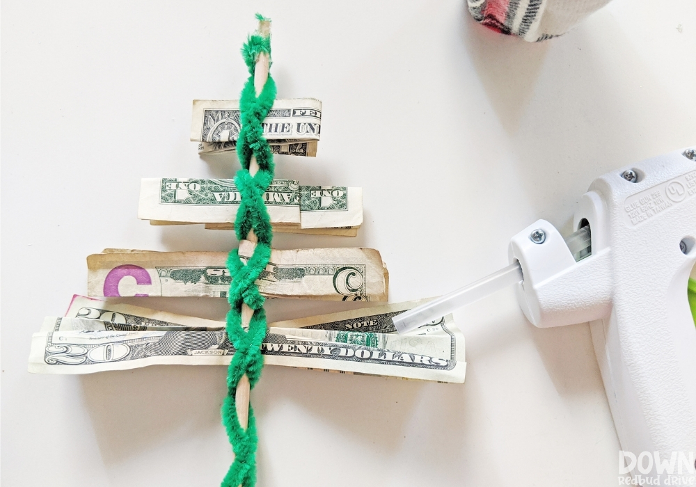 Overhead shot of the money added to the money Christmas tree gift.