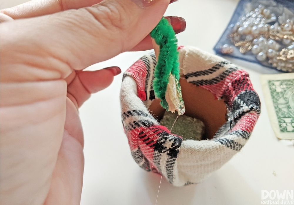 Close up of the money Christmas tree stem being glued into the pot.