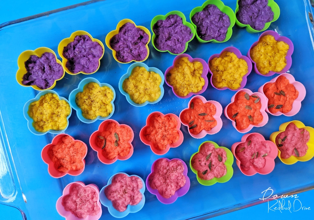 flower silicone molds filled with colorful paper pulp on a blue background