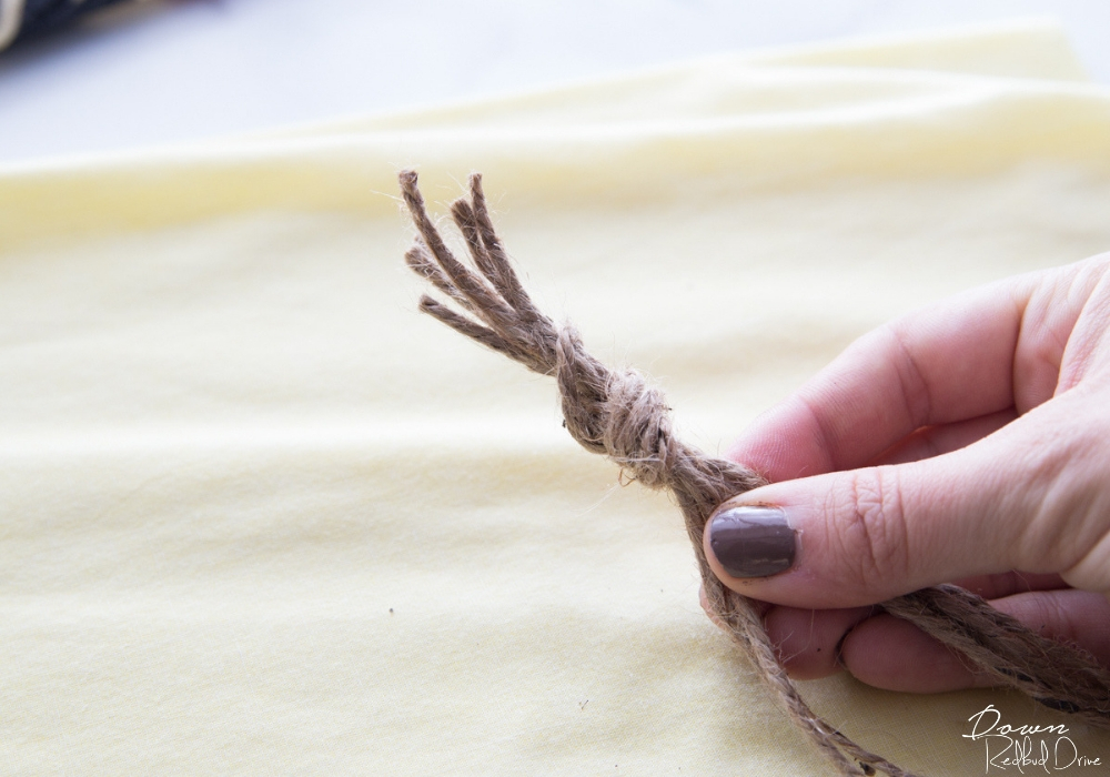 several pieces of twine tied into a know being held by a hand