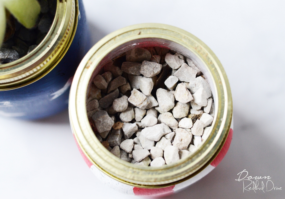 Gravel on top of succulent soil in a mason jar.