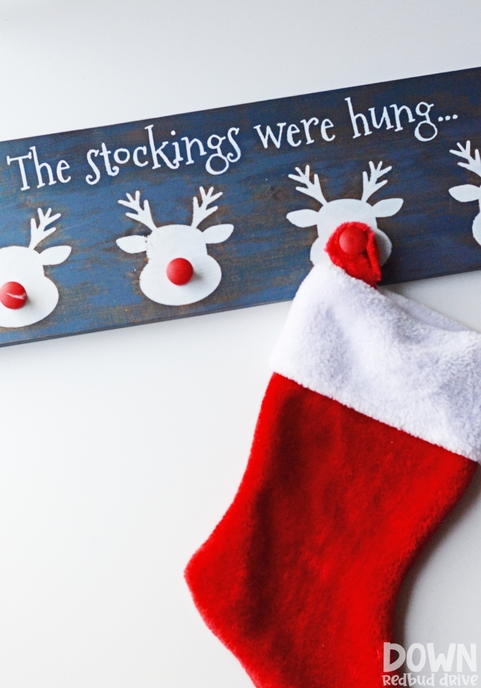 Tall shot of a Christmas stocking hanging from a reindeer stocking holder.