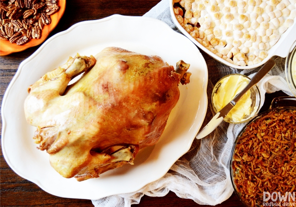 Wide overhead shot of the Roasted Turkey Recipe surrounded by Thanksgiving sides.