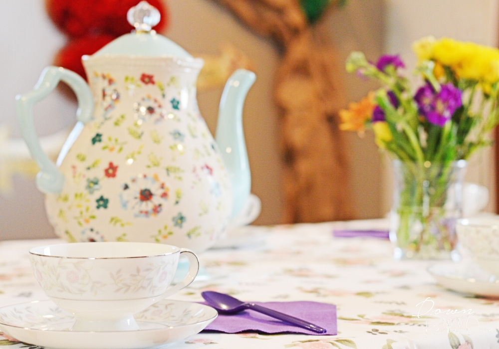 floral teapot and tea cups on a floral tablecloth