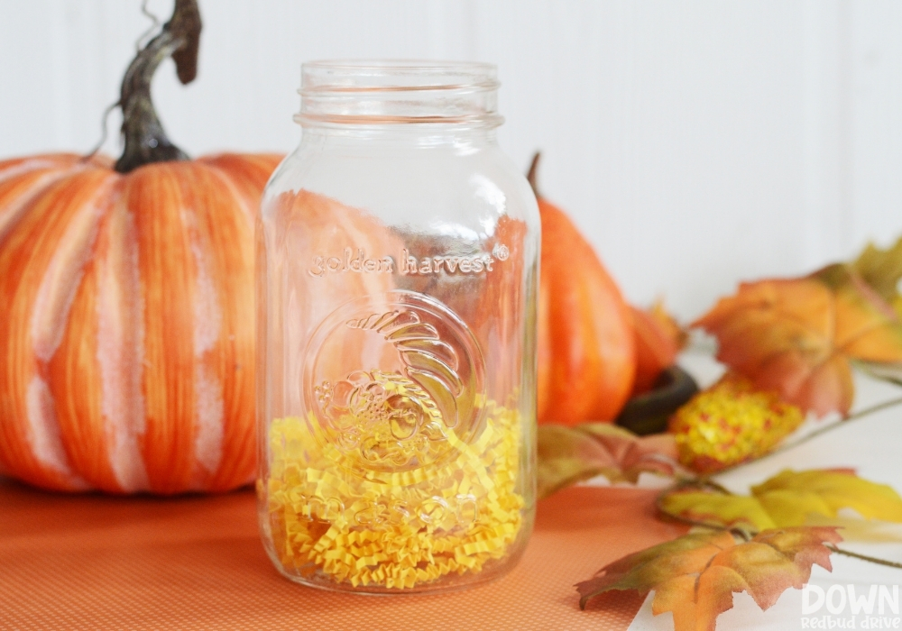 Closeup of yellow crinkle paper in the bottom of a mason jar.