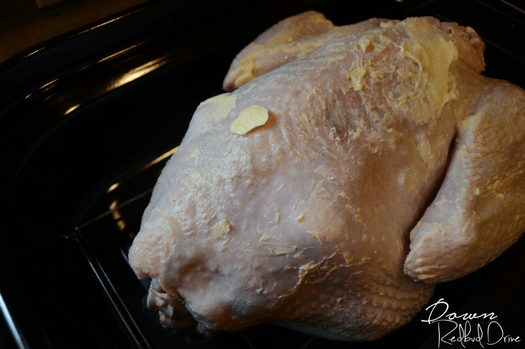 Overhead shot of a buttered turkey in a roaster.