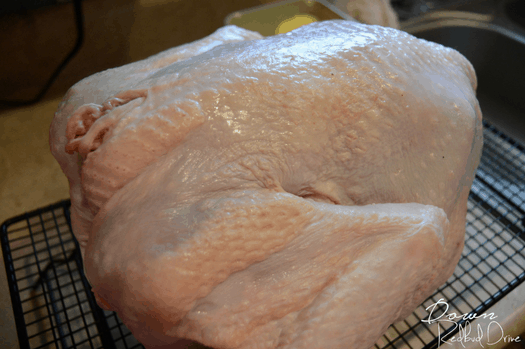 Picture of the uncooked turkey on a cooling rack.