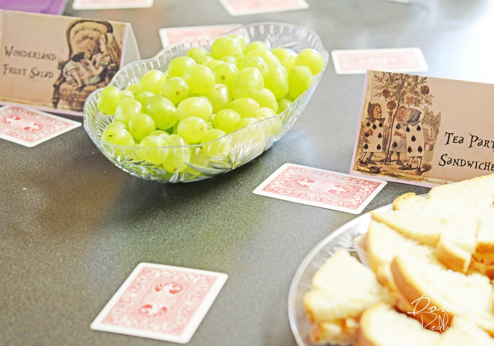 playing cards on a table at an Alice in Wonderland pbirthday party with a bowl of green grapes