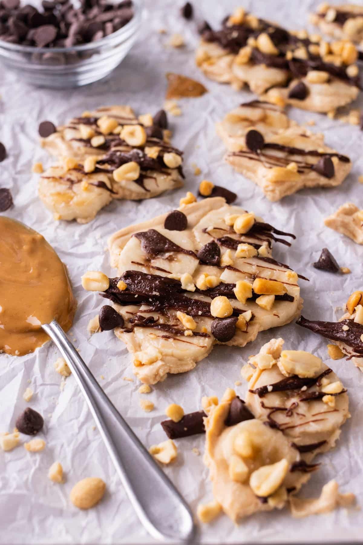 several broken pieces of chunky monkey frozen yogurt bark on a piece of parchment paper.