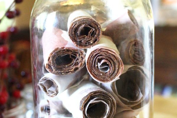 a mason jar filled with strawberry zucchini fruit leather rolls