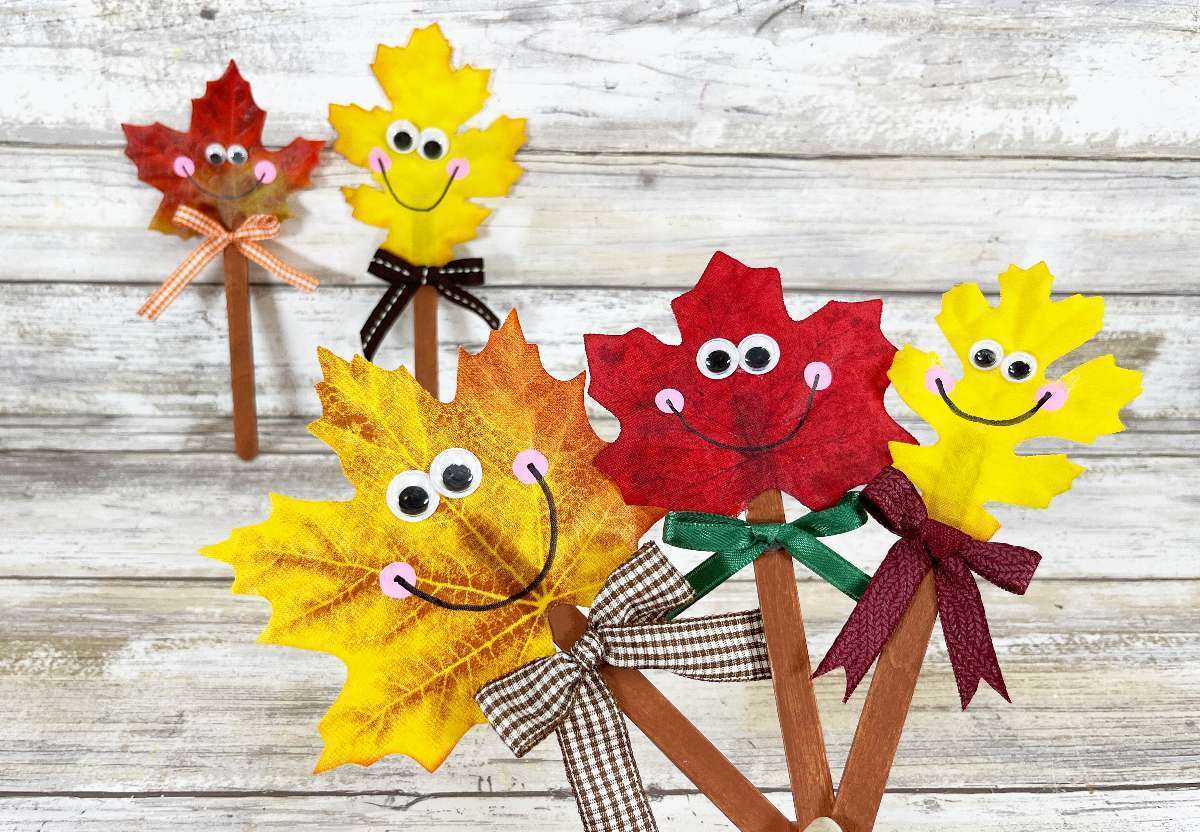 stick puppets made of fall leaves a popsicle sticks.