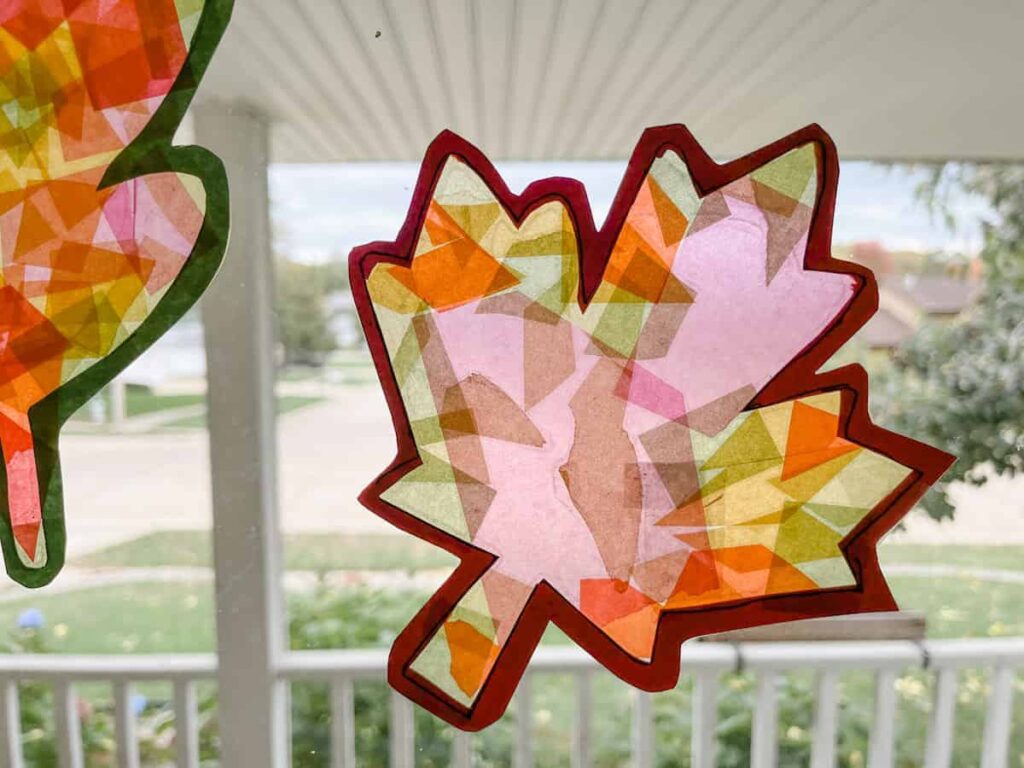 fall leaf paper suncatchers on a glass window