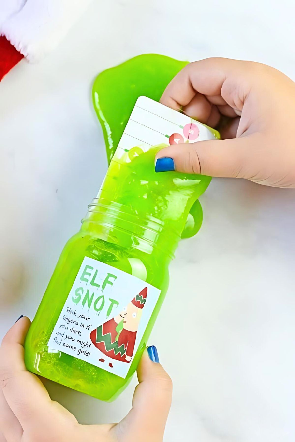 elf snot slime in a mason jar with a hand pulling some of the slime out of the jar