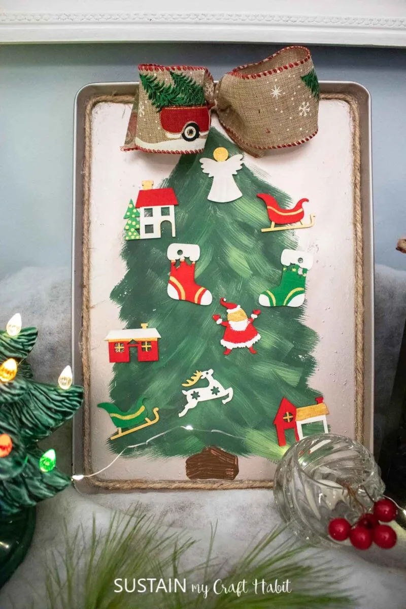 a cookie sheet painted to looks like a Christmas tree with magnetic ornaments on it