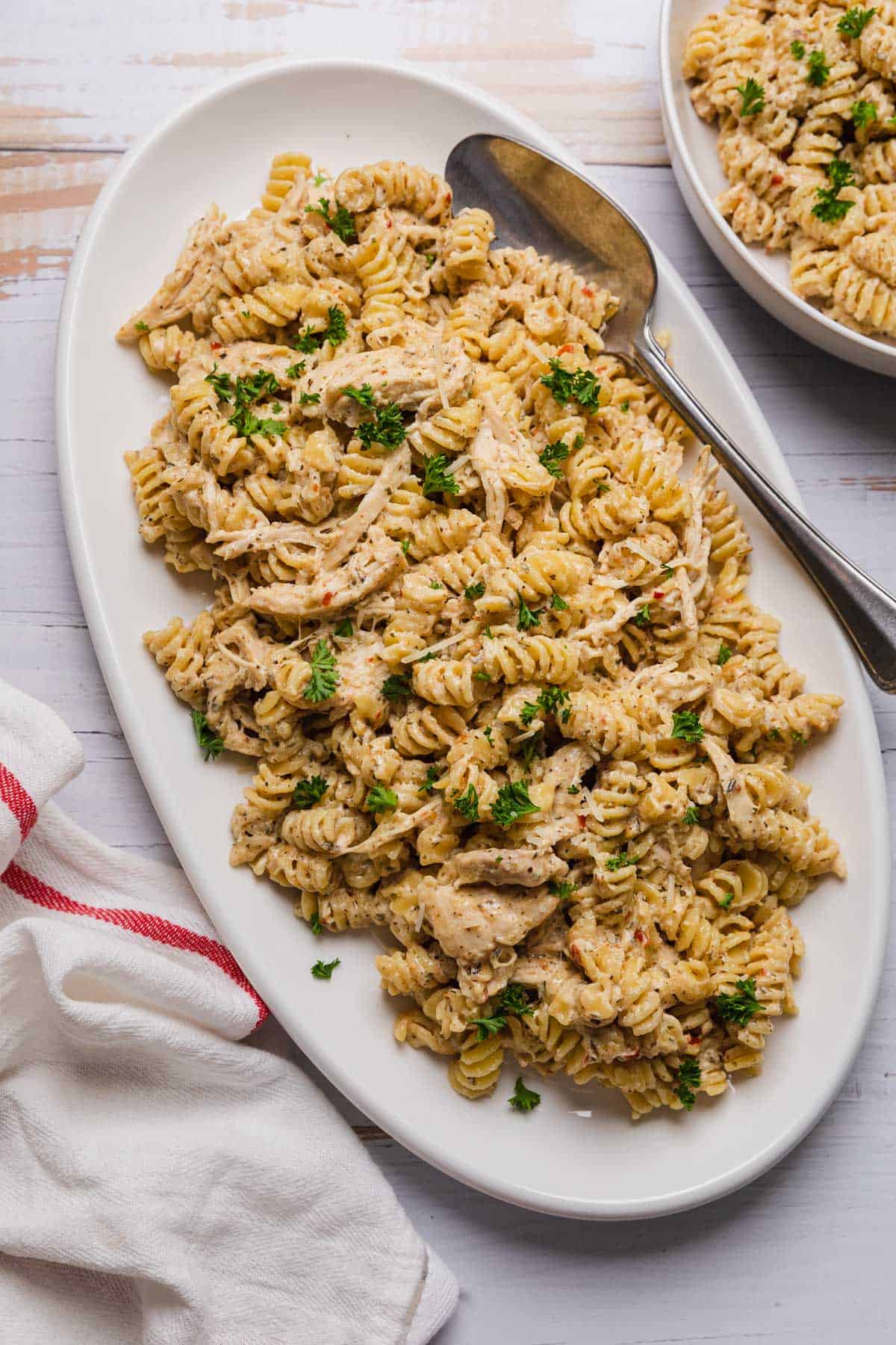 A white platter filled with crockpot garlic parmesan chicken pasta