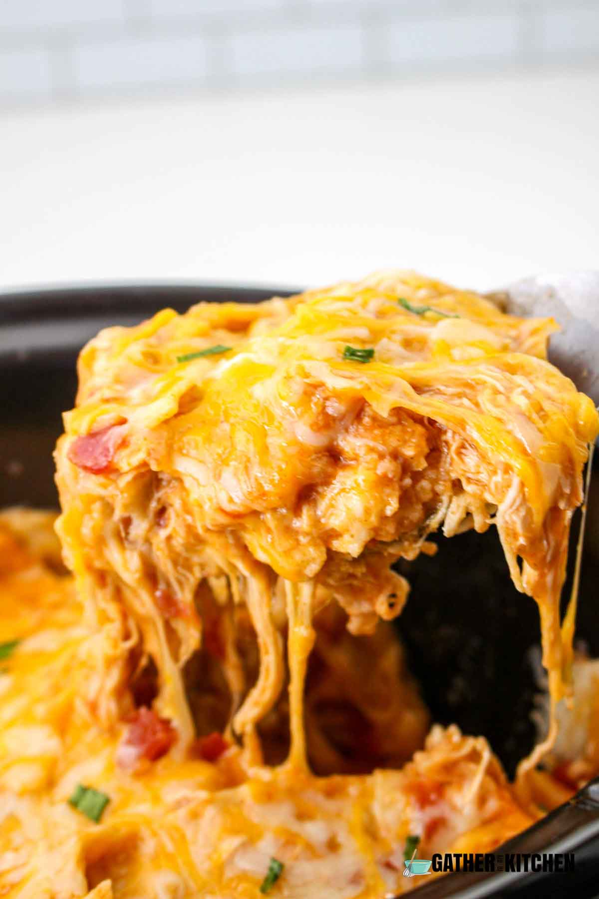 Slow cooker enchilada casserole slice being pulled up from the crockpot